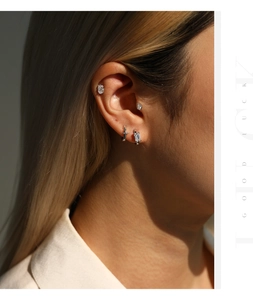 Primer plano detallado de pendientes de moissanita en la oreja, en elegante plata de ley S925 pura.