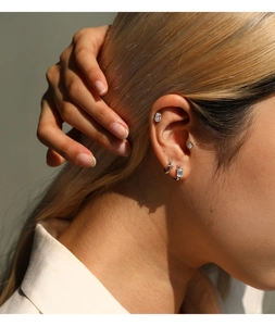 Primer plano de pendientes de moissanita brillantes en la oreja de una modelo asiática