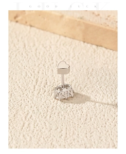 Vista de detalle de un pendiente de botón de plata de ley S925 con corazón de moissanita