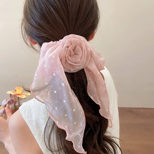 Vue arrière d'un chouchou en mousseline rose à pois avec détail de ruban floral.
