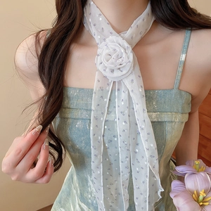 Détail d'un tour de cou en soie à imprimé floral blanc avec une grande rose
