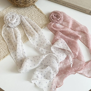 Gros plan de barrettes à fleurs élégantes avec de longs rubans en mousseline rose et blanc