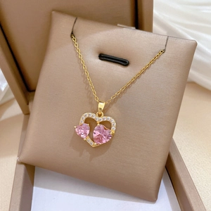 Detaillierte Nahaufnahme einer goldenen Herzkette mit schimmernden rosa Zirkonia-Steinen