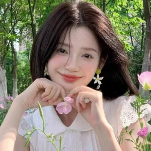 Beautiful white flower resin earrings shown on model in a sunny forest background