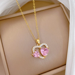 Nahaufnahme einer vergoldeten Titanstahlkette mit elegantem rosa Herz Zirkonia Anhänger