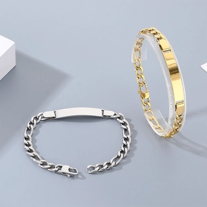 Gedetailleerde macro weergave van Figaro-ketting ID-armbanden in zilver en goud voor gravures