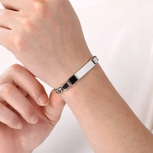 Detailopname van een zilverkleurige Figaro-schakelarmband met graveerbare metalen staaf