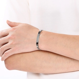 Detailweergave van een minimalistische gebogen roestvrijstalen armband om de pols