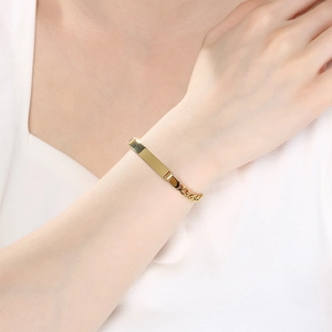 Detailopname van gouden Figaro-schakelarmband met graveerbare staaf
