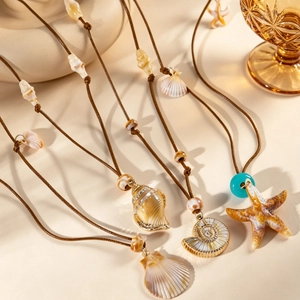 Vue macro d'un collier bohème avec pendentifs coquillages et cordon tressé marron