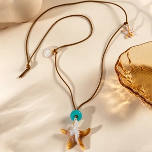 Détail du collier étoile de mer vintage avec perle bleue et coquillages sur cordon brun