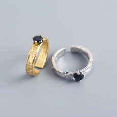 Detailed close-up of gold and silver hammered rings featuring black round gemstones