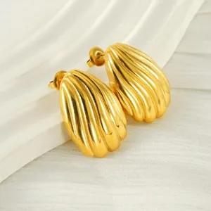 Detail shot of golden textured round stud earrings with spiral ribbed shell design
