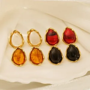 Waterdrop stud earrings in four colors displayed on white silk with golden metal trim