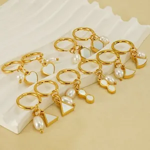 Detail of gold-plated geometric earrings with white mother-of-pearl and pearl charms