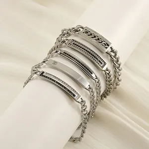 Detail showing five assorted 8mm titanium steel Cuban link bracelets for men on fabric