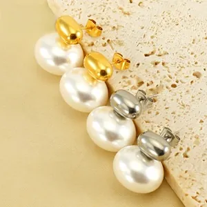 Detail of elegant gold and silver stainless steel earrings with oval pearls on stone