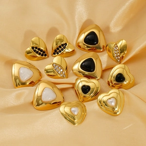 Macro shot of vintage gold stud earrings with natural pearl and evil eye details