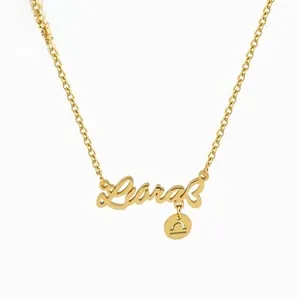 Detalle del colgante Libra dorado con letras cursivas y un pequeño amuleto símbolo