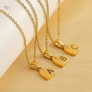 Detailed macro view of three golden heart necklaces with A B C alphabet engravings and zircon