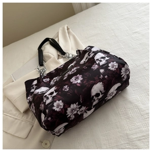 Detail of gothic skull and purple floral prints on a large black waterproof tote bag