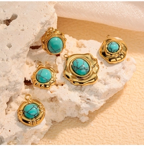Detailed view of five gold-plated turquoise pendants on decorative white stones