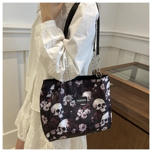 Detail of floral skull print tote bag featuring FASHION label and metal chain strap