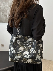 Floral skull print tote bag with metal chain strap shown on a model's shoulder
