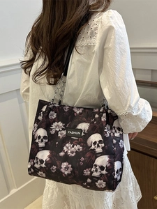 Gothic black tote bag with skull floral print and silver chain strap shown on model
