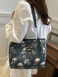 Gothic floral skull printed tote bag with metal chain strap shown on model's shoulder