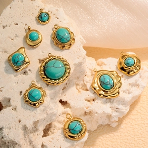 Gold plated stainless steel geometric turquoise stone pendants on travertine stone