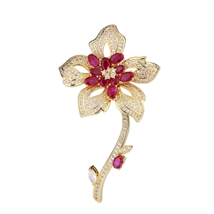 Luxurious flower brooch with red and white gemstones on gold-plated floral stem