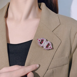 Vintage silver镂空brooch with red gemstones pinned on a dark brown wool blazer lapel