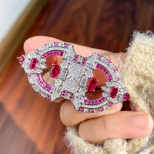 Macro shot of vintage brooch with red rubies and diamonds pinned on a soft sweater