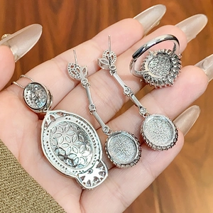 Macro view of silver jewelry set including necklace, tassel earrings and pave ring