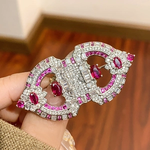 Elegant Art Deco brooch with pink and white gemstones on a vintage silver geometric frame