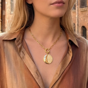 Goldene Büroklammerkette mit Sonne und Mond geprägtem Münzanhänger an einem Modell