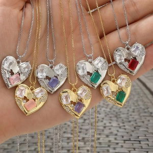 Close-up of heart-shaped zircon pendants in 18K gold and silver plating on hand
