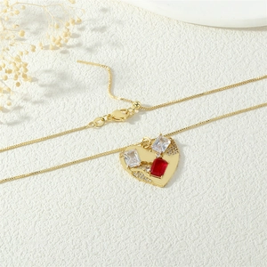 Detail of adjustable gold heart pendant necklace with red and white rectangular zircon stones