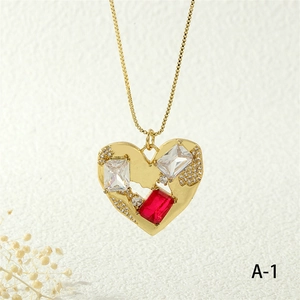 Close-up of heart pendant necklace with red and clear crystals on a gold box chain
