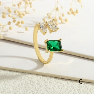 Détail d'une bague ajustable plaquée or 18K avec zircons vert émeraude et cristaux clairs