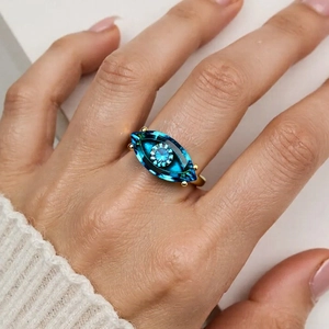 Vergoldeter Ring mit blauem Teufelsauge im Marquise-Schliff, am Finger getragen