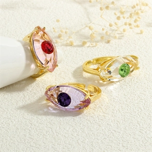 Detailansicht von drei Evil-Eye-Kristallringen in Pink, Grün und Violett mit Goldfassung