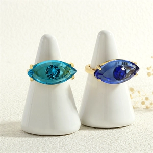Makroaufnahme von Evil-Eye-Ringen mit blauen Kristallen auf Goldbändern und Ringständern