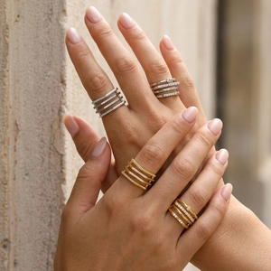 Detail of multilayer geometric rings in gold and silver plating with zircon micro-paving