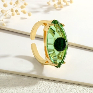 Detailaufnahme des goldenen Evil-Eye-Rings mit olivgrünem Kristall auf weißem Hintergrund