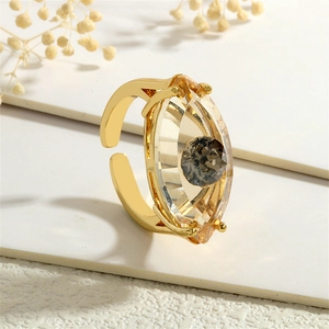 Detailaufnahme: Goldener offener Ring mit Glasauge im Marquise-Schliff und grauem Stein