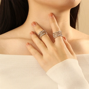 Detail of stacked multi-layer silver rings with cubic zirconia on a model hand