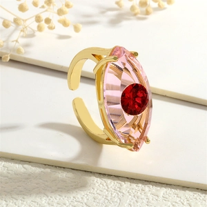 Detail eines goldenen Rings mit pinkem Markis-Kristall und rotem Augen-Design