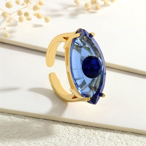 Makroaufnahme eines verstellbaren Goldrings mit blauem Teufelsauge-Motiv aus Glas